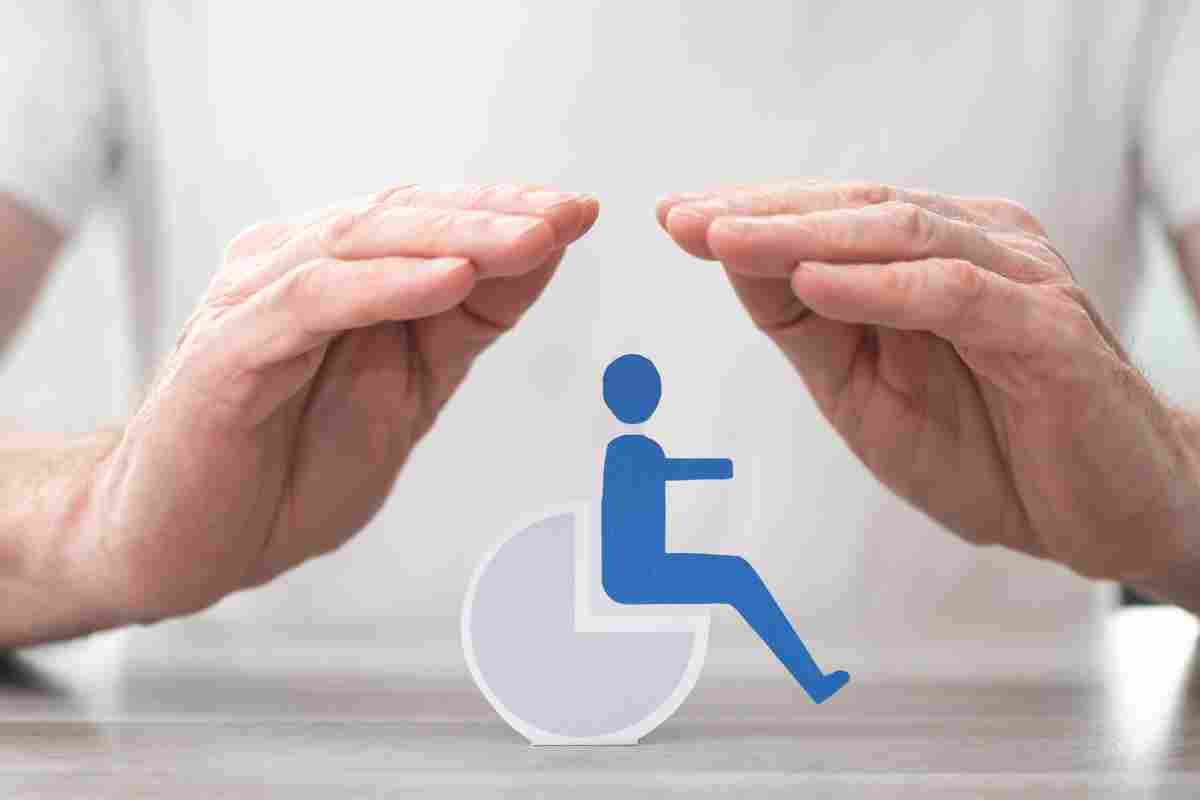 due mani riparano il logo di una sedia a rotelle