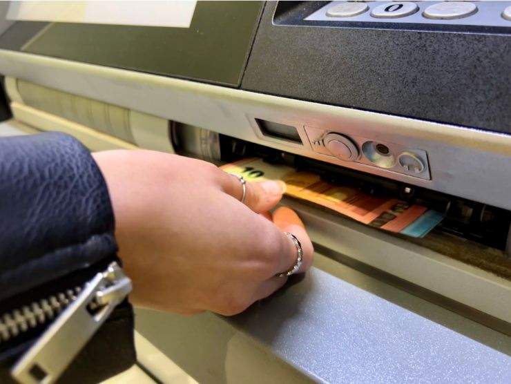 donna che ritira soldi al bancomat