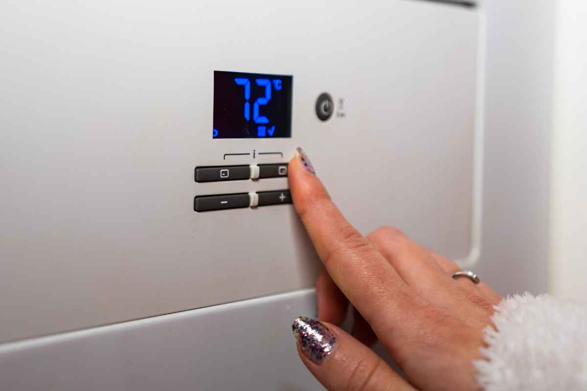 una mano accende i riscaldamenti in casa