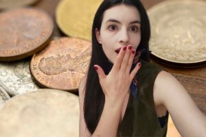 Una ragazza stupita e sullo sfondo monete rare