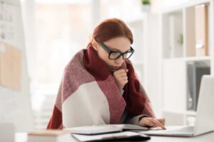 donna che sente freddo in casa con coperta sulle spalle