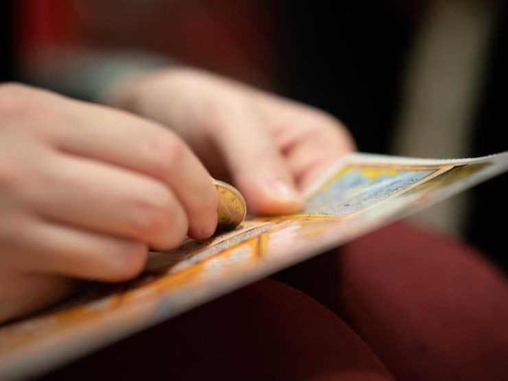 persona che gratta biglietto gratta e vinci