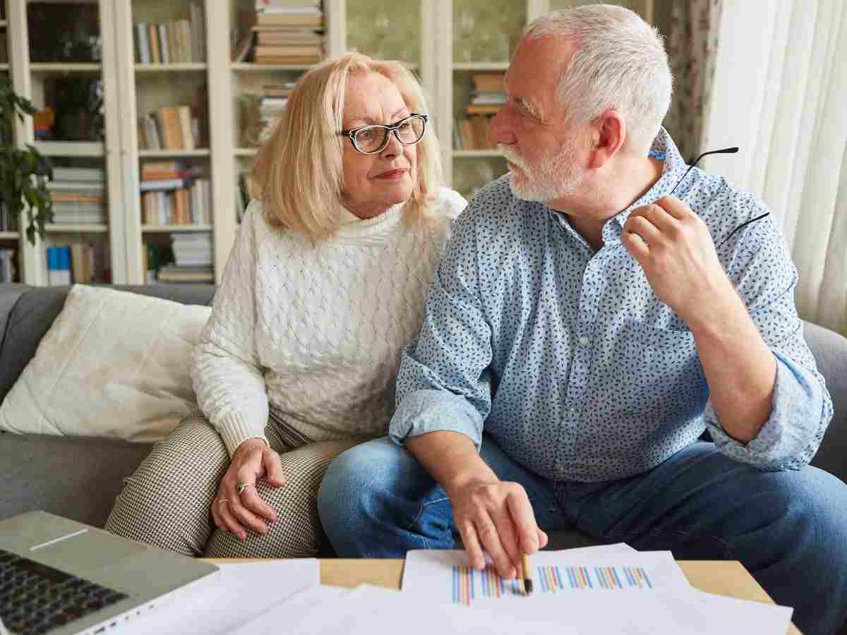 coppia di anziani fa calcoli su un grafico