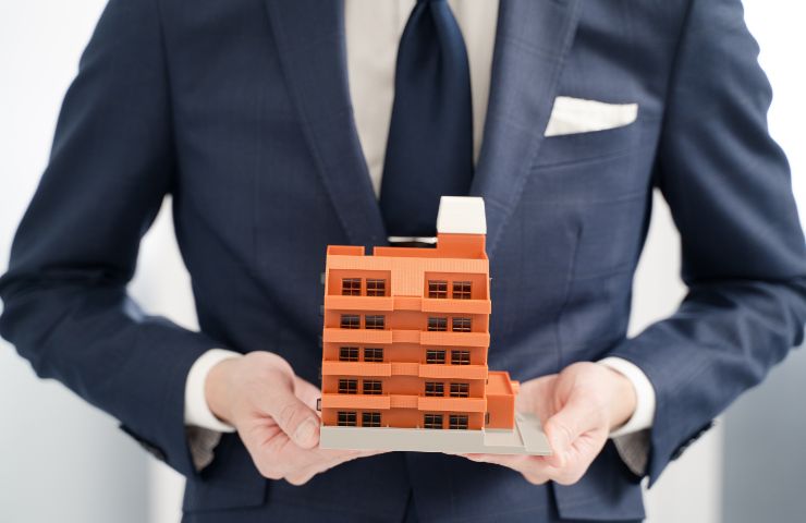 amministratore con sagoma palazzo in mano